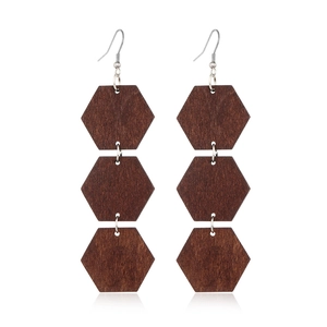 Detailed view of dark brown triple hexagon geometric wooden earrings with silver hooks