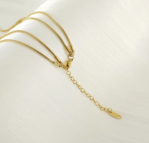 Detailansicht der 18K vergoldeten Schlangenkette mit S. STEEL Logo Gravur auf dem Anhänger
