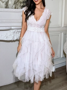 Gros plan du corsage en dentelle à col en V et jupe en tulle sur la robe blanche
