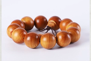 Macro detail of aged Thuja sutchuenensis wood beads showing natural cloud grain texture