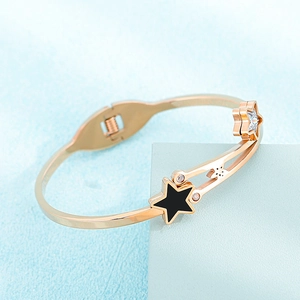 Detail view of rose gold star cuff with black enamel and sparkling zircon stones