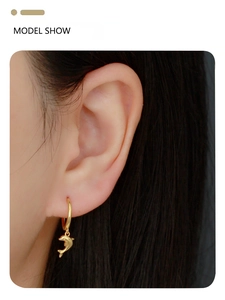 Model wearing gold dolphin dangle earrings, close-up showing ocean-inspired S925 silver jewelry