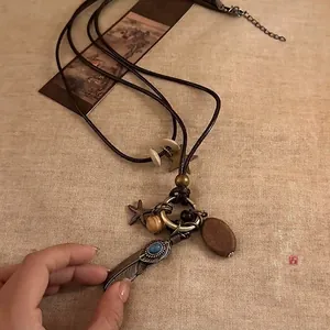 Bohemian multilayer necklace with feather charm and turquoise beads on brown leather cord