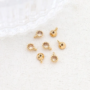 Close-up of gold-plated charms with champagne zircon stones for DIY jewelry making