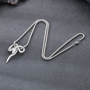 Detail of silver snake pendant with small crystals on a steel box chain necklace