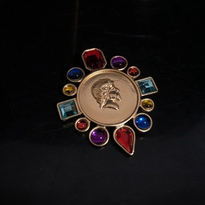 Macro view of vintage palace style brooch with colored gemstones and cameo relief