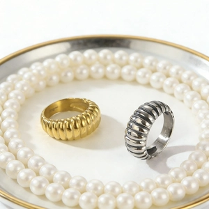 Detailed macro view of gold and silver ribbed croissant rings with pearls decoration