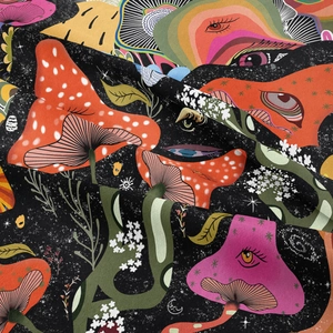 Close-up of bohemian tapestry showing colorful mushroom details and starry fabric texture