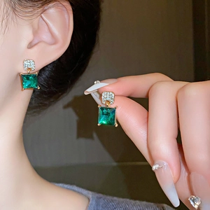 Vue détaillée des boucles d'oreilles émeraude carrées avec dorure et zircons blancs