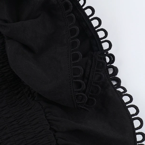 Close-up of black corset top featuring detailed smocking and hollow lace trim details