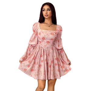 Détail de l'imprimé floral rose sur une robe à col carré avec des manches bouffantes