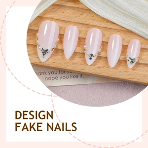 Handmade almond press-on nails in nude pink with butterfly and pearl embellishments