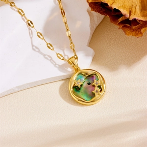 Close-up of golden necklace with iridescent shell pendant and three zircon star details