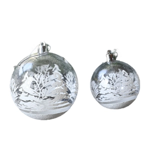 Clear Christmas balls with white snow and pine tree landscape for festive decoration