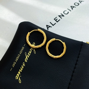 Elegant gold twisted rope hoop earrings with a textured spiral finish on black leather background