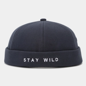 Gros plan de la broderie Stay Wild sur un bonnet docker noir avec texture en coton fin