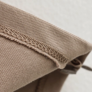 Khaki knit off-shoulder top showing detailed hem stitching and premium fabric texture