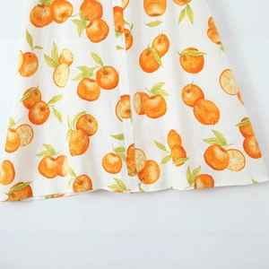 Weißes Leinenkleid mit lebhaftem Orangen- und Blattmuster in der Detailansicht