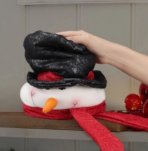Close-up of a snowman Christmas topper with a black hat, carrot nose and red glitter scarf