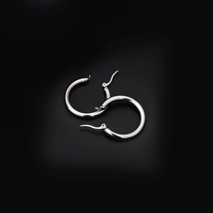 Detailed view of polished silver stainless steel hoop earrings with engraving on black background