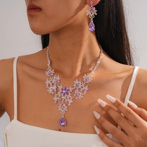 Close-up of elegant purple zircon flower necklace and earrings set worn by a model