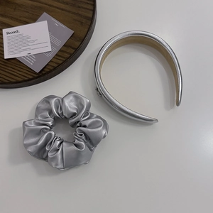 Silver PU leather Y2K headband and scrunchie set on a minimalist aesthetic background