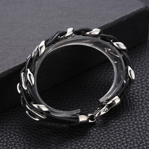 Macro view of woven black leather cord with silver stainless steel metal chain links