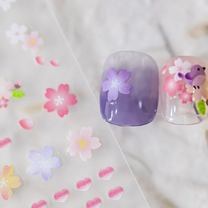 Floral spring nail stickers featuring sakura flowers and birds on purple gradient nails