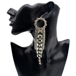 Close-up of long silver fringe earrings with rhinestones on a black mannequin model
