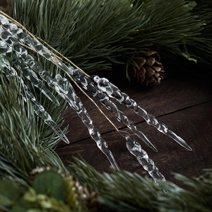 Clear acrylic icicle ornaments for Christmas tree decoration on rustic pine branches