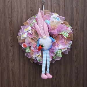 Couronne de Pâques avec gnome aux oreilles de lapin et rubans roses sur bois sombre