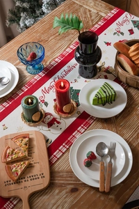 Detail of red and white woven Christmas table runner with snowman and festive patterns