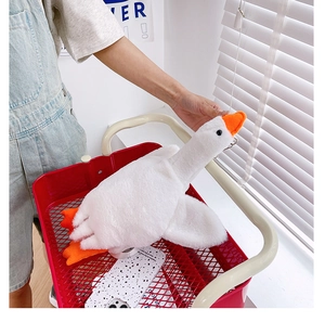 Detail of soft white goose plush backpack with orange beak being held in a shopping cart