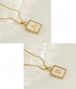 Close-up of square 18K gold plated stainless steel letter pendant with shell inlay and crystals
