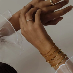 Close-up of gold-plated titanium steel chain bracelets and minimalist rings on a model
