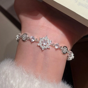 Elegant silver flower pearl bracelet with zircon snowflake charm on a female wrist