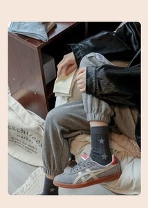 Close-up of grey crew socks with star pattern paired with striped casual sneakers