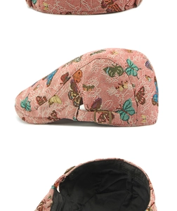 Detail of pink jacquard beret featuring colorful butterfly patterns and metal side buckle