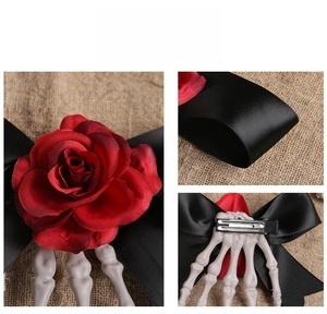 Detail showing Gothic skeleton hand hair clip with red rose and black satin bow accent