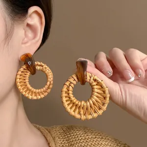 Bohemian round woven raffia earrings with amber resin accents for beach vacation