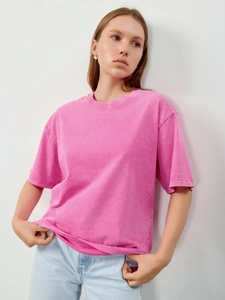 Detail of pink vintage washed cotton T-shirt showing fabric texture and crew neck design