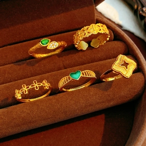 Détail de bagues vintage plaquées or avec zircon vert et motifs ajourés élégants