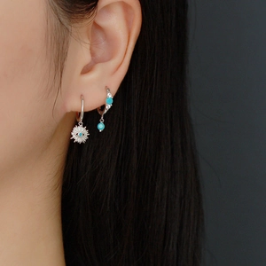 Detailed shot of S925 sterling silver evil eye hoop earrings with blue zircon on model