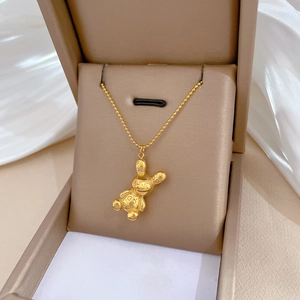 Golden titanium steel rabbit pendant necklace with bead chain on beige jewelry box