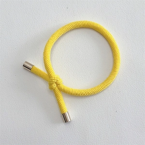 Close-up of bright yellow braided elastic hair tie with silver alloy metal fasteners