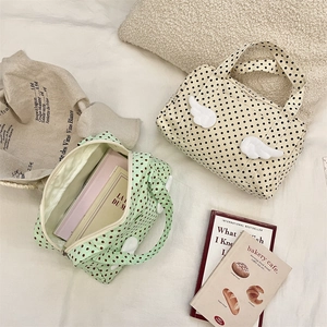 Overhead view of polka dot canvas bags featuring 3D plush wings and top handles