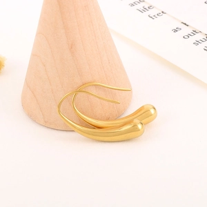 Macro shot of polished gold water drop earrings with elegant geometric fluid design