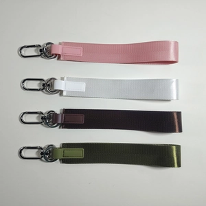 Dettaglio di cinturini in tessuto rosa, bianco, marrone e verde con ganci in metallo