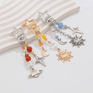 Detailed view of celestial sun, moon and star charms on beaded metal keychains