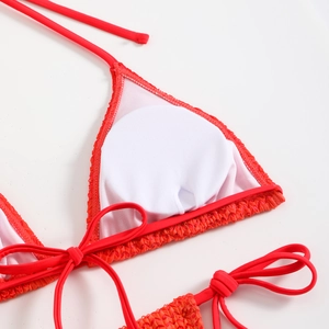 Primo piano del top bikini rosso strutturato con cuscinetti rotondi rimovibili